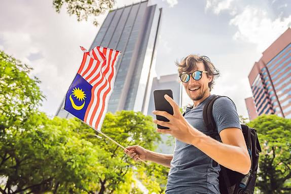 Visitor holding the Malaysian flag in the city